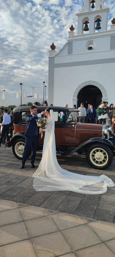 Santi, the 1930 Ford Model A, outside a white Lanzarote church with the bride and groom